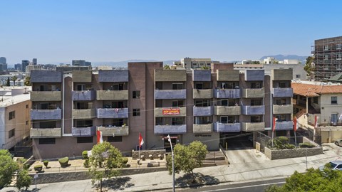 A large apartment complex with a red sign in front.
