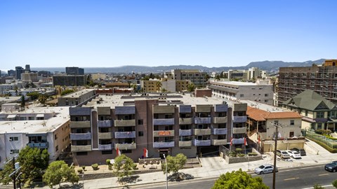A large apartment complex is surrounded by buildings and trees.