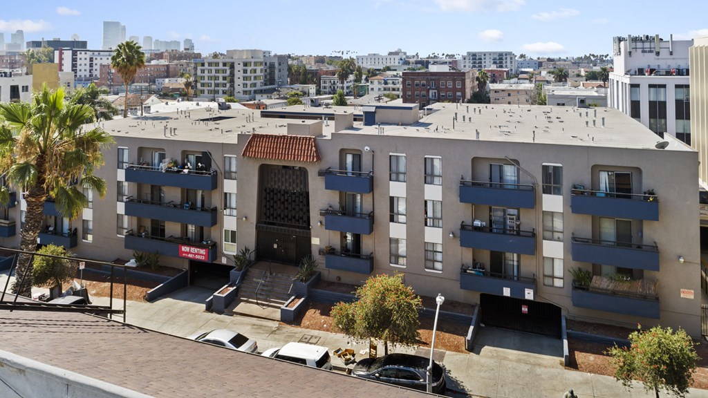 Apartment complex with a parking lot in front.