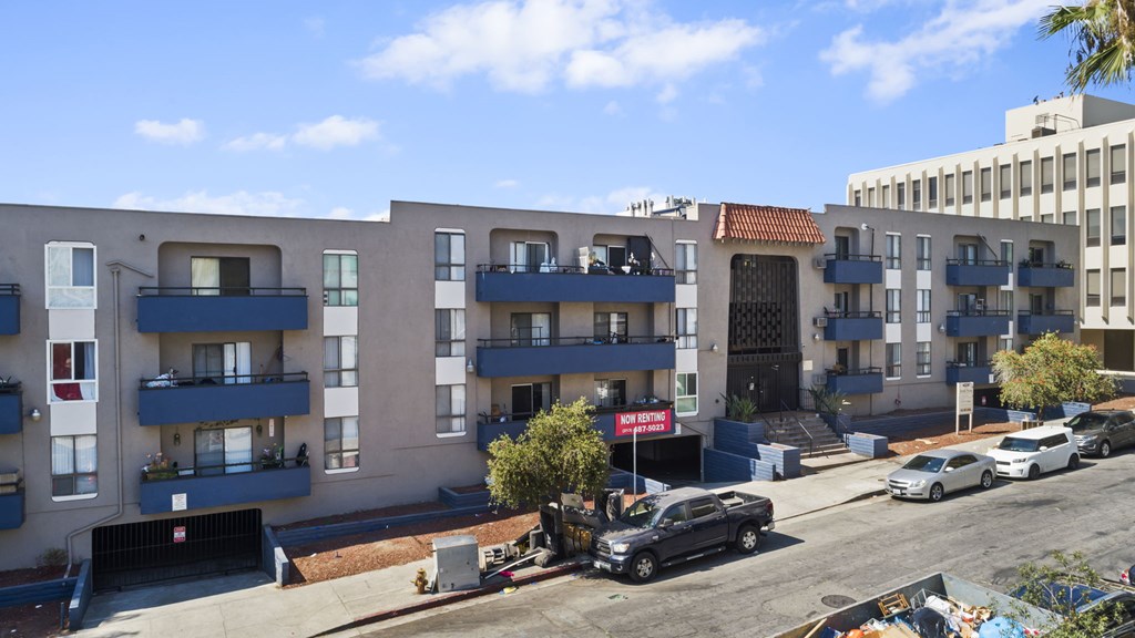 A street view of a residential area with cars parked on the side of the road.