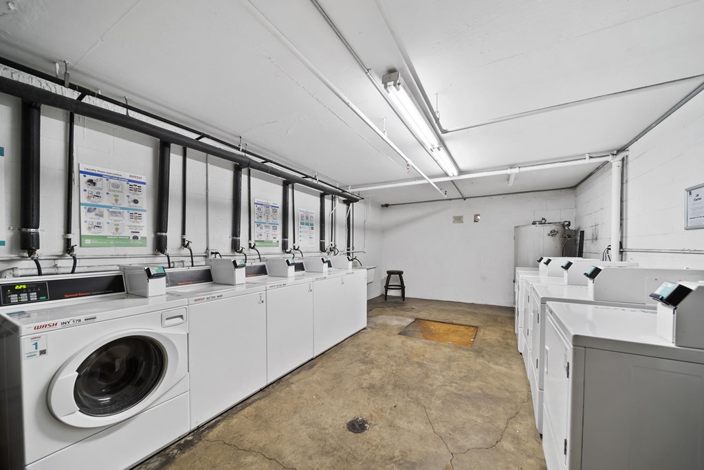 A laundry room with washing machines and a hole in the floor.