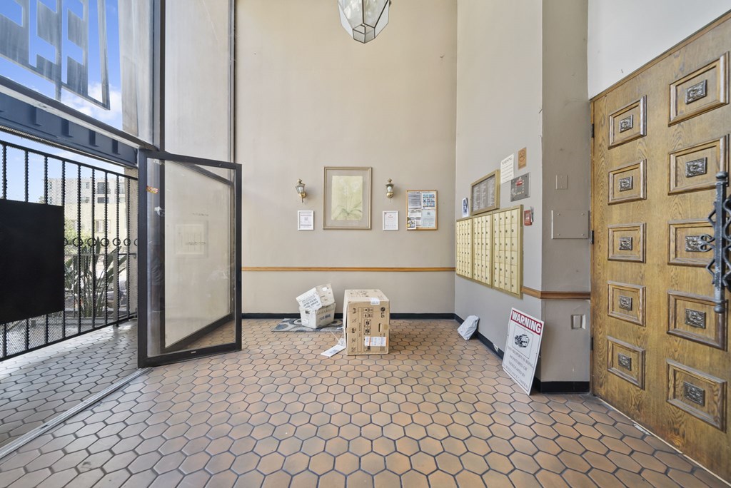 A hallway with a tile floor and a wooden door on the right.
