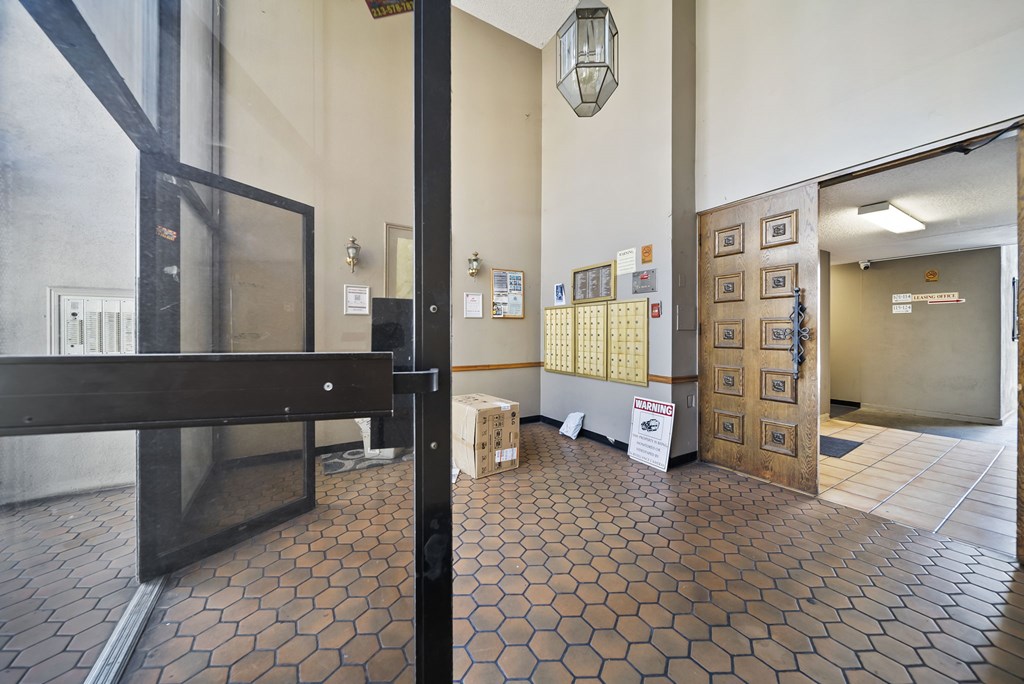 A hallway with a tile floor and a white sign on the wall.