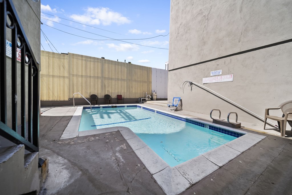 A small pool with a diving board and a sign that says "SWIMMING POOL".