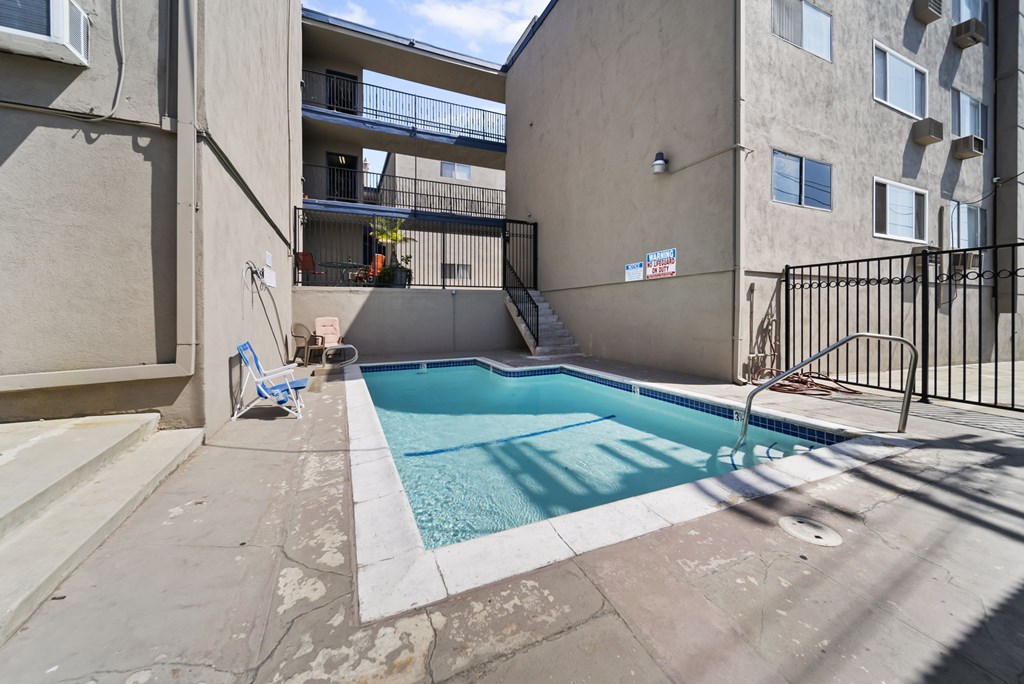 A small pool in a courtyard surrounded by buildings.
