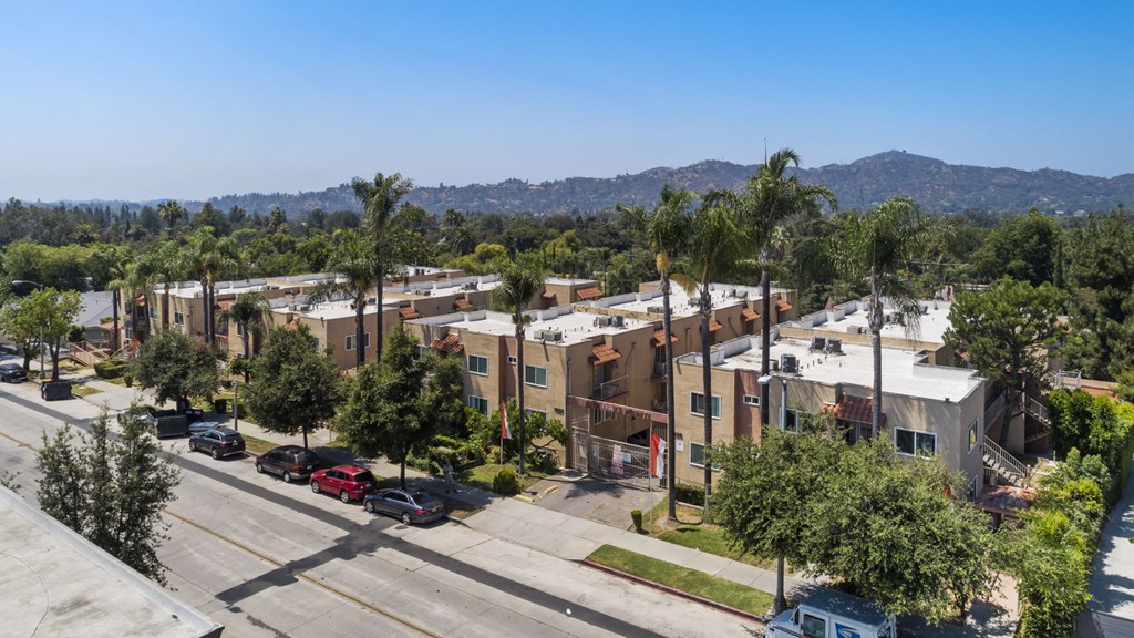 A street view of a residential area with cars parked on the side of the road.