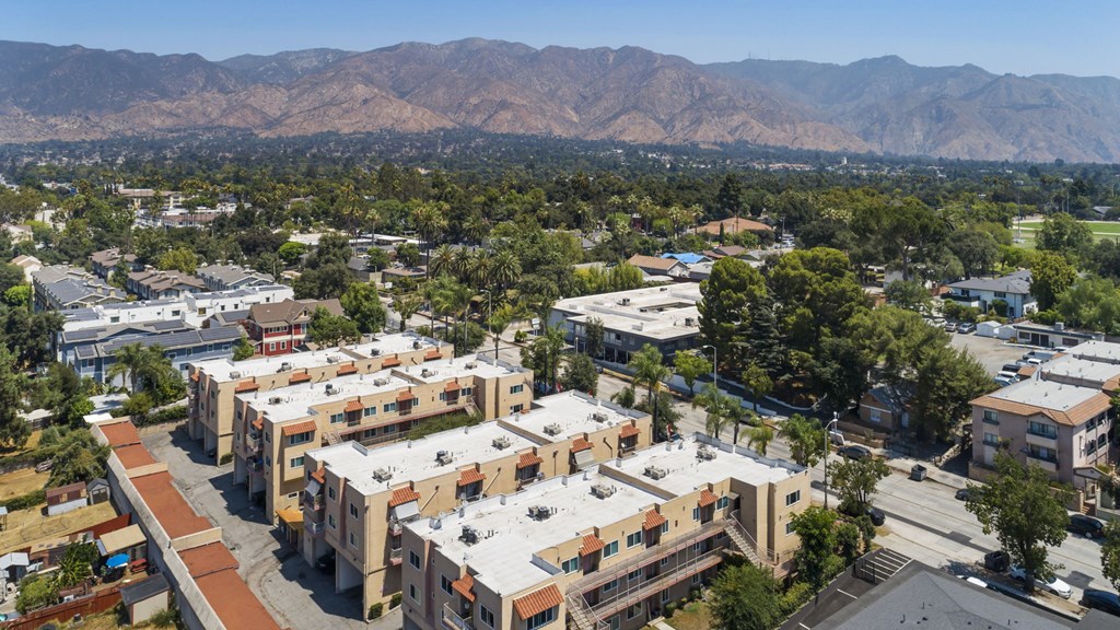 A view of a residential area with apartment buildings and a mountain range in the background.