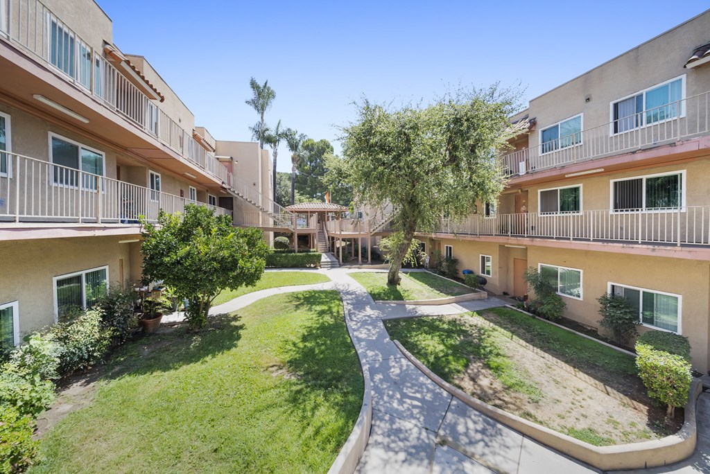 A courtyard surrounded by apartment buildings on a sunny day.