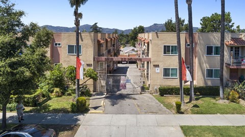A gated entrance to a residential complex with a flag on a pole.