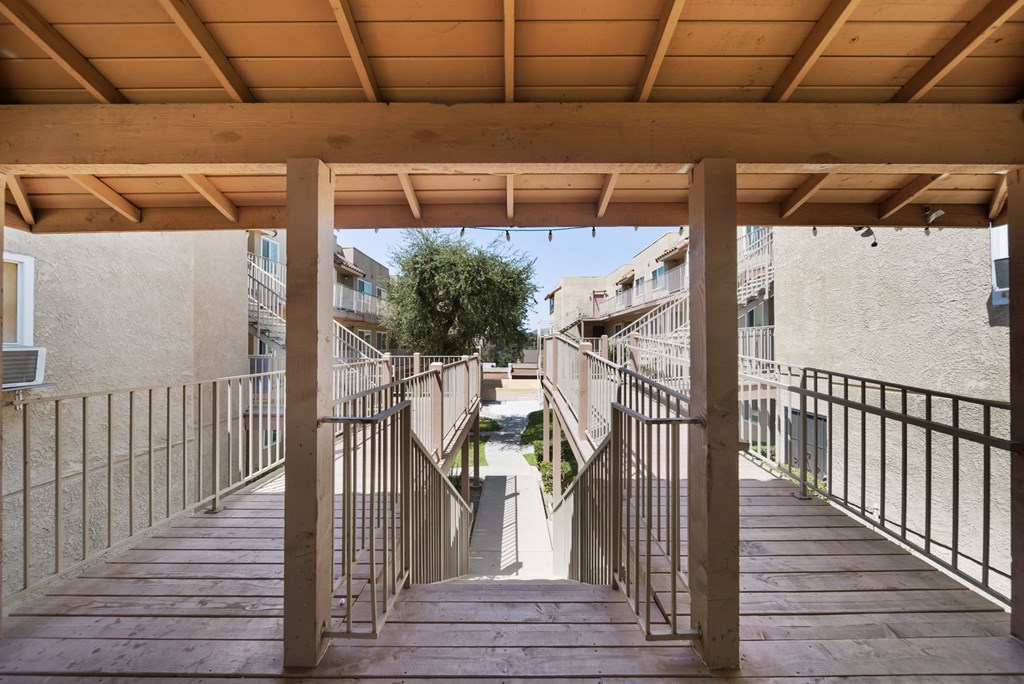 A wooden staircase with metal railings leads up to a building.