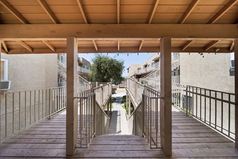 A wooden staircase with metal railings leads up to a building.