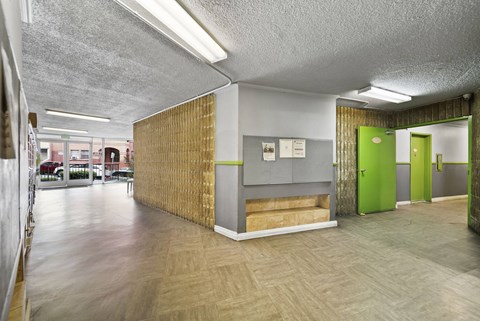 A long hallway with a green door at the end.
