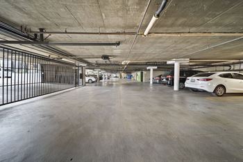 A spacious parking garage with a white car parked on the right side.