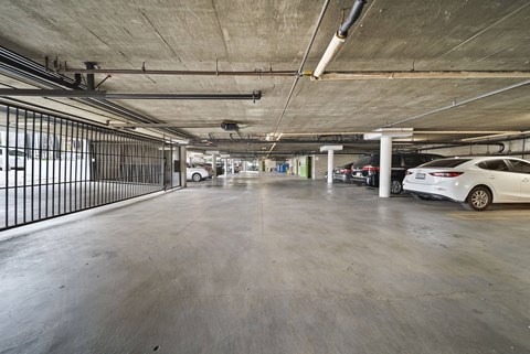 A spacious parking garage with a white car parked on the right side.