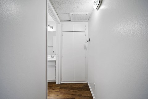 A white bathroom with a white door and a white sink.