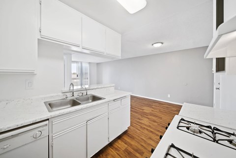A kitchen with white cabinets and a white counter top.