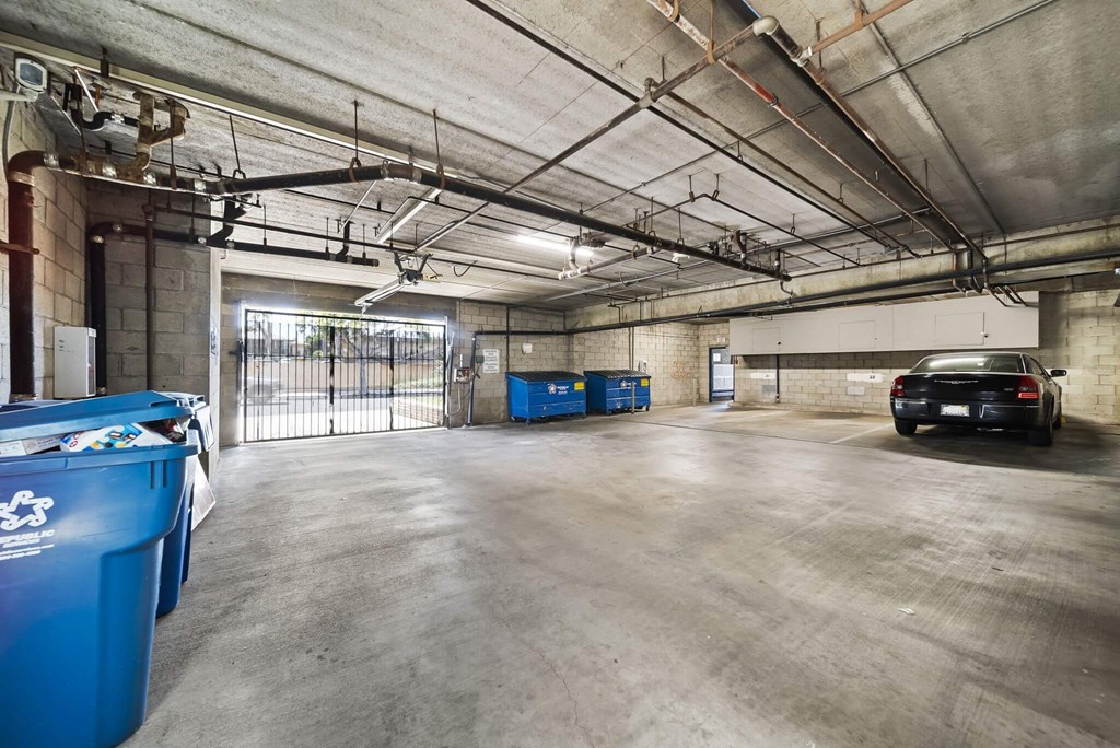 A large, empty garage with a black car parked in the far corner.