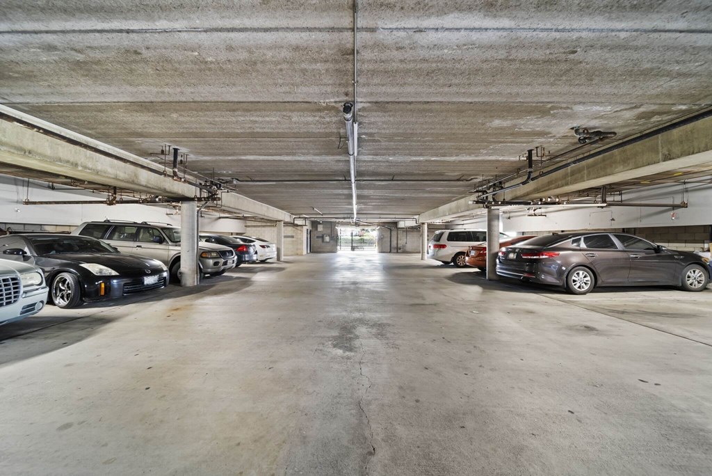 A parking garage with several cars parked in it.