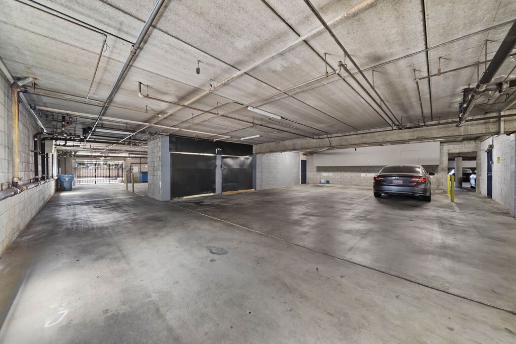 A car is parked in a large, empty parking garage.