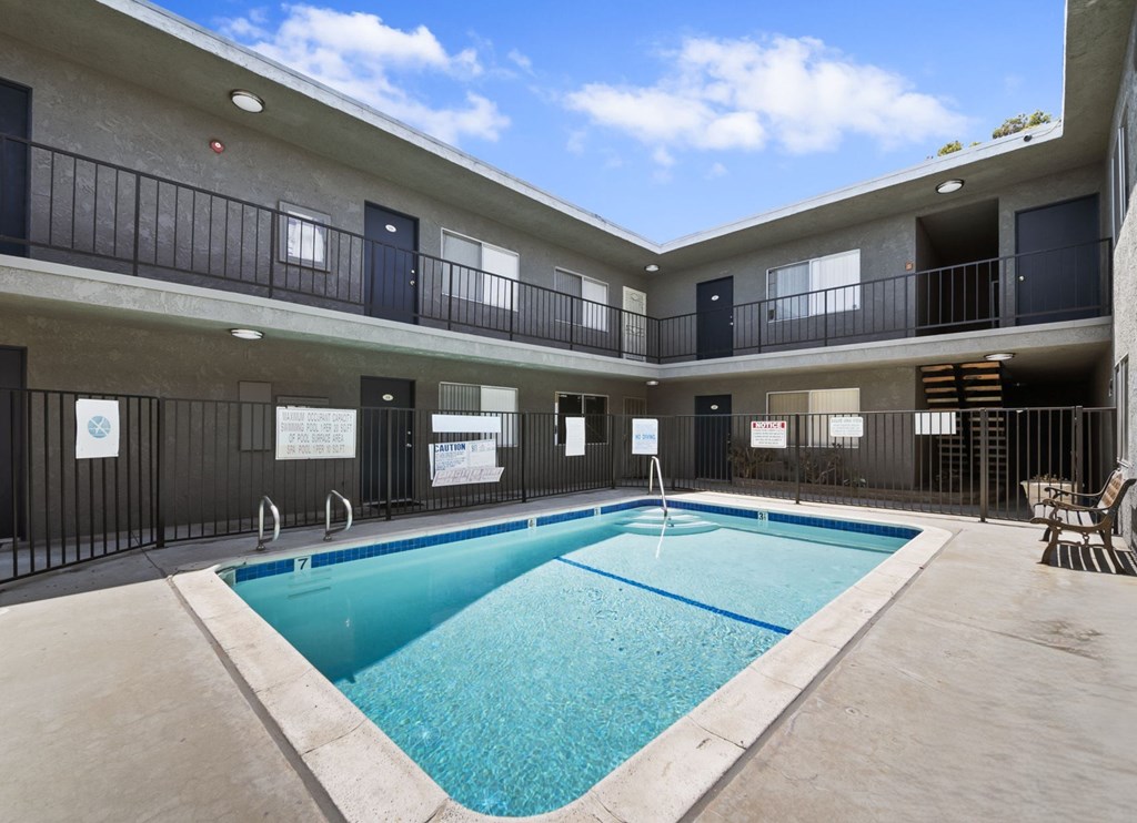 A large indoor swimming pool in a building with balconies.