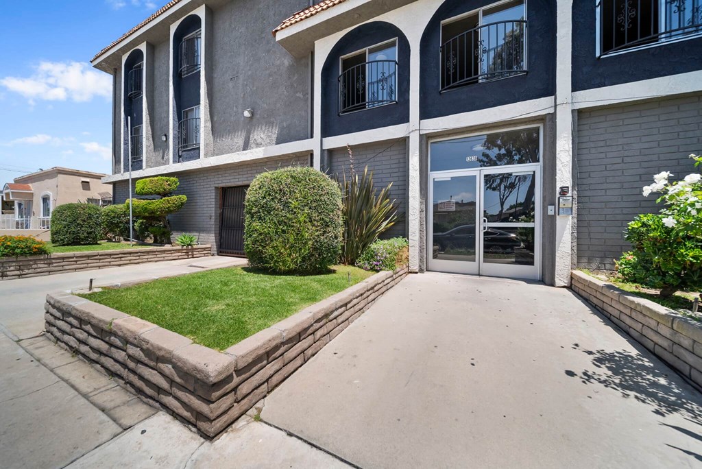 A house with a grey and white exterior and a green lawn in front.