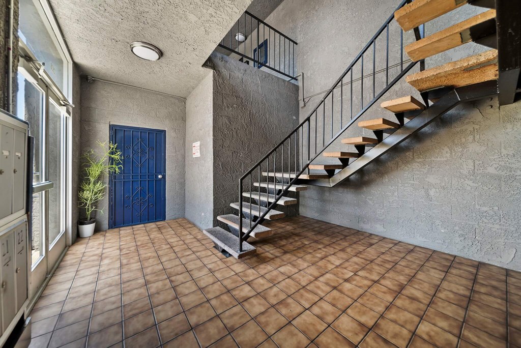 A tiled floor leads to a staircase in a house.