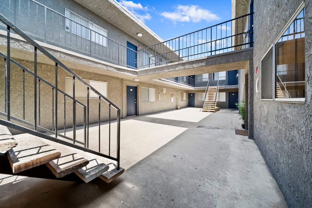 A concrete staircase with metal railings leads to a balcony.