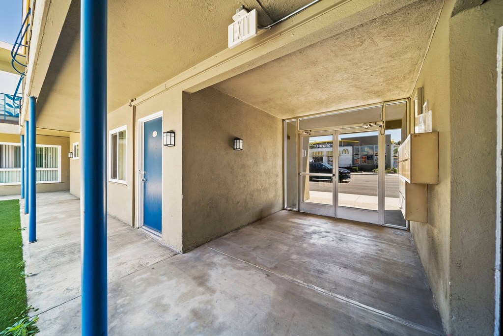 A blue door is on the left side of a building.