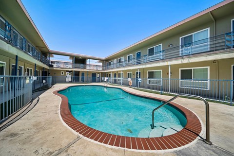 A swimming pool in a courtyard surrounded by apartment buildings.