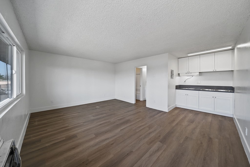 A room with wooden flooring and white walls.