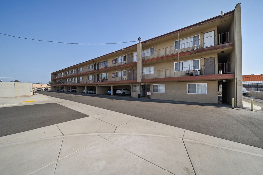A large apartment complex with a parking lot in front.