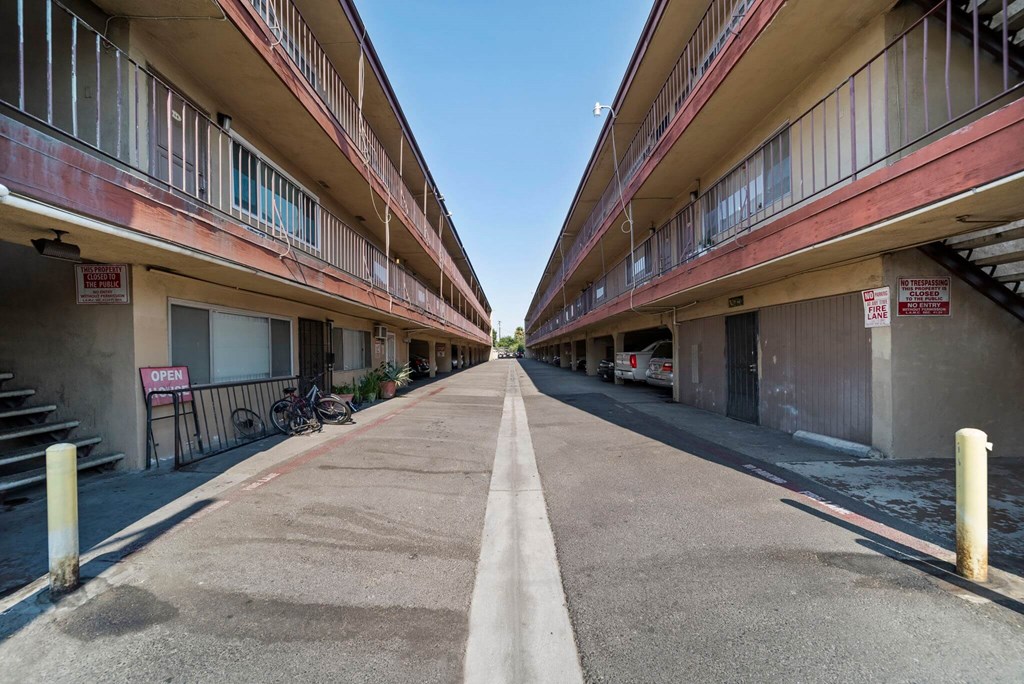 A long, narrow road separates two rows of apartment buildings.