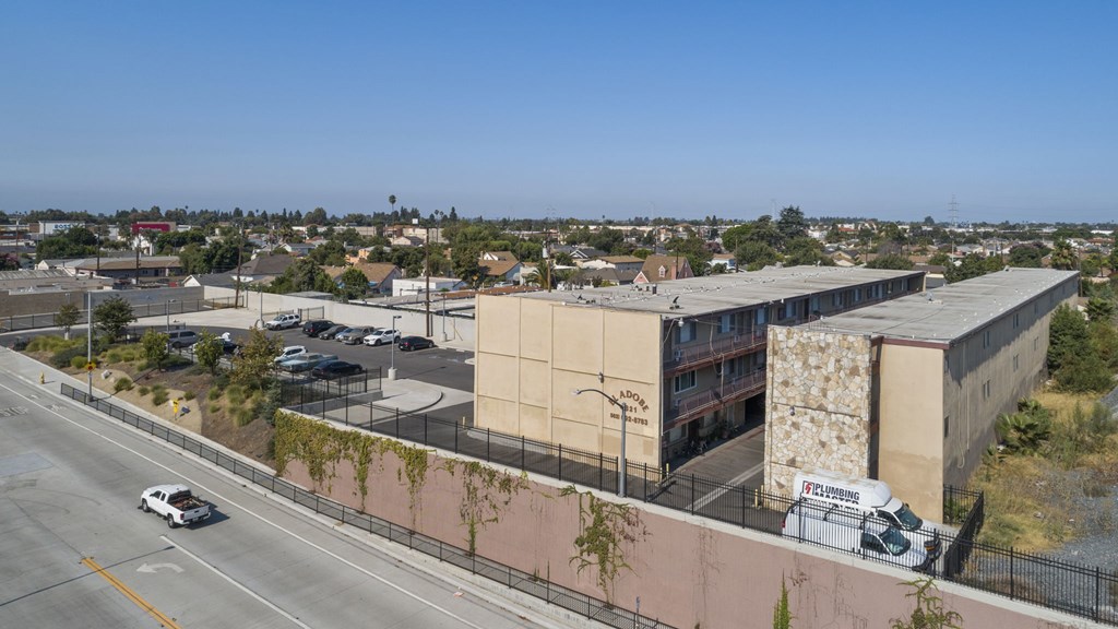 A white car is driving on a road next to a building.