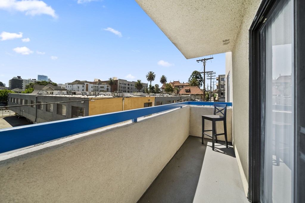 A balcony with a chair and a view of the city.