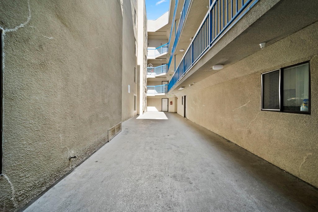 A long, narrow alleyway between two buildings with balconies on the upper floors.