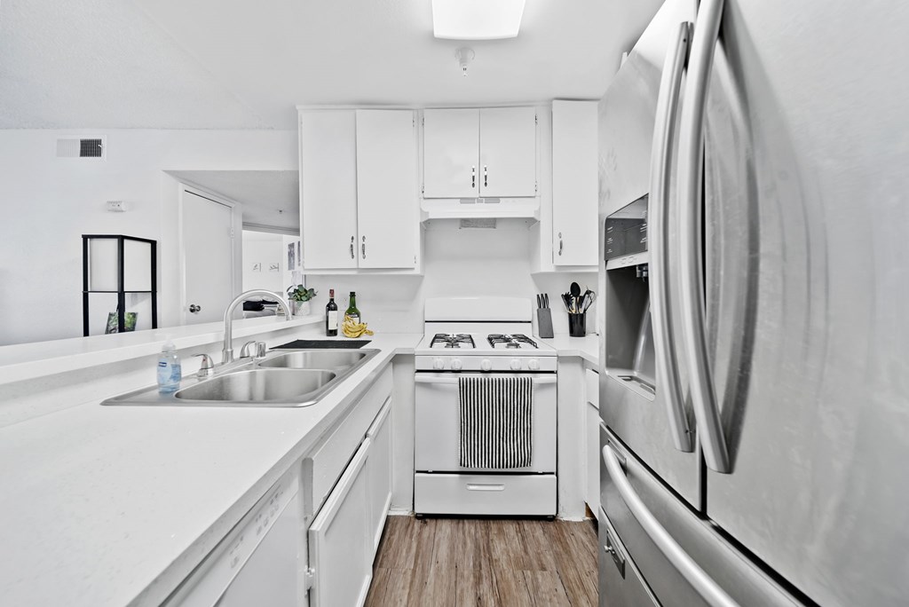 A modern kitchen with white appliances and cabinets.