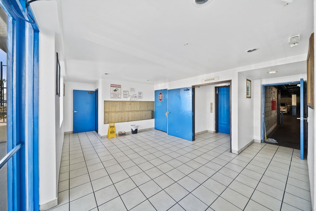A hallway with blue doors and white walls.