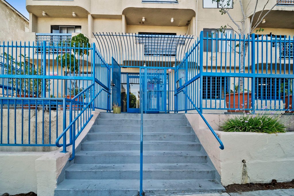 A blue gate leads to a building entrance.