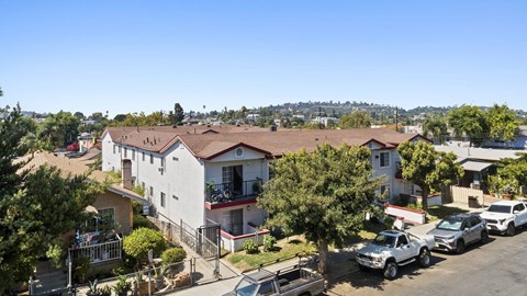 A sunny day in a residential area with houses and parked cars.