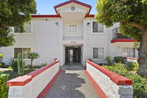 A white building with a red roof and a black awning with the number 5708 on it.