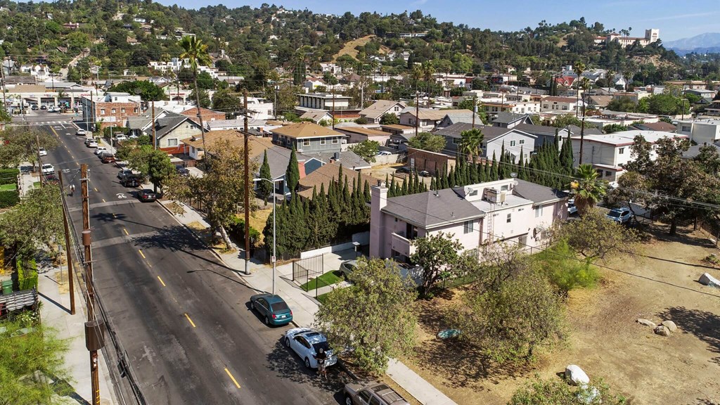 A street view of a residential area with houses and parked cars.