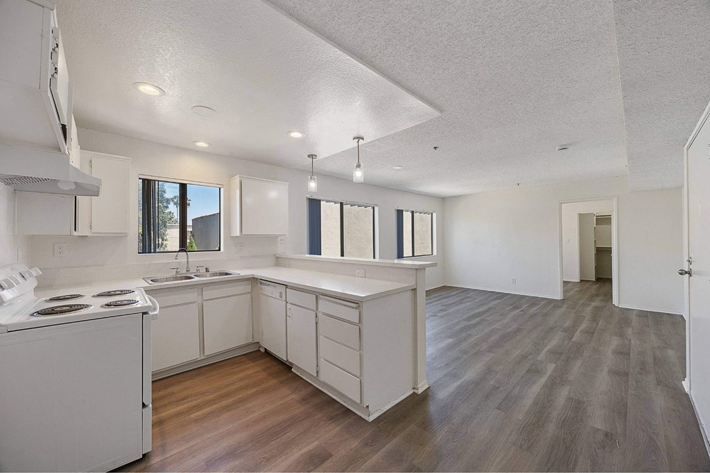 A kitchen with white cabinets and a stove top oven.