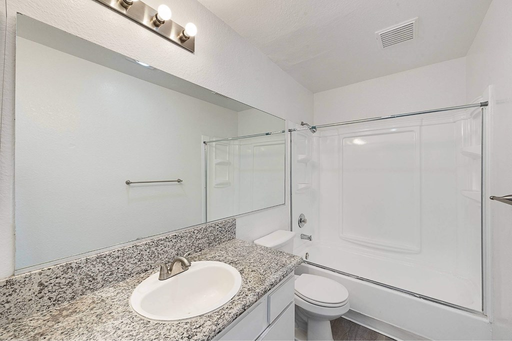 A bathroom with a sink, toilet, and shower.