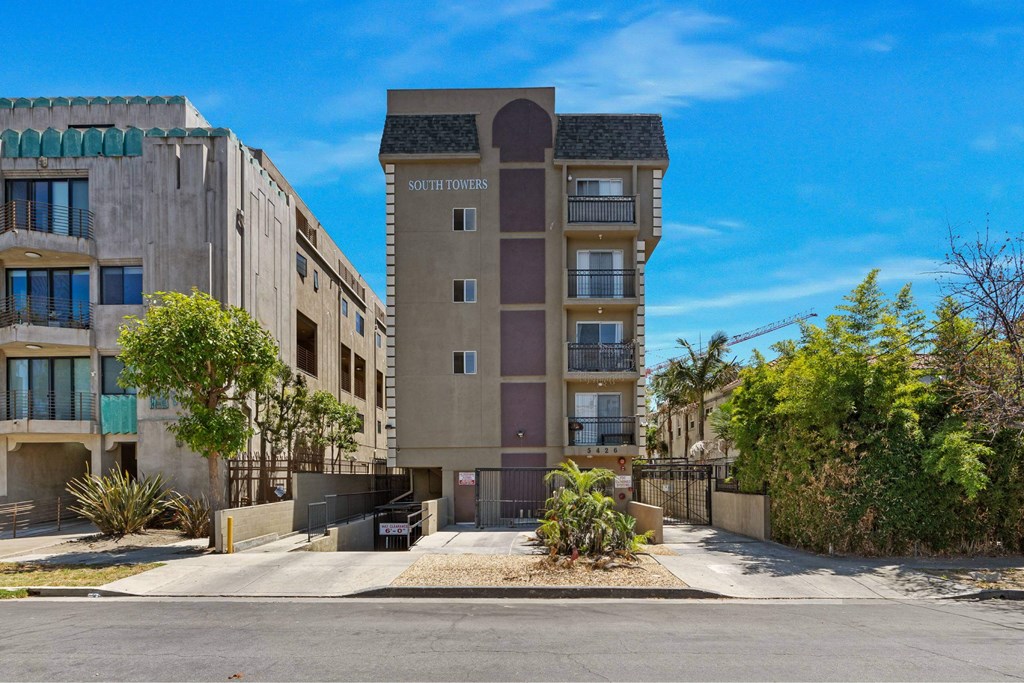 A modern apartment building named South Towers is shown with a clear blue sky in the background.