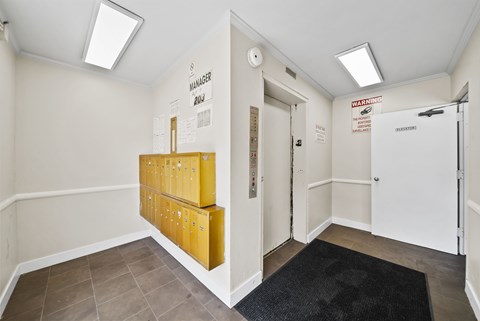 A hallway with a black rug and a yellow filing cabinet.