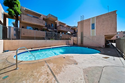 A pool in a courtyard surrounded by buildings.