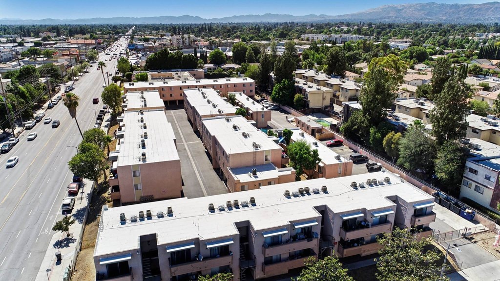 A large apartment complex sits in the middle of a city street.
