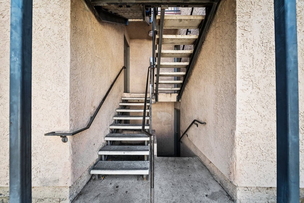 A staircase with metal handrails leads up to a doorway.