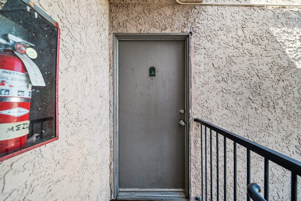 A grey door with a black handle is closed.