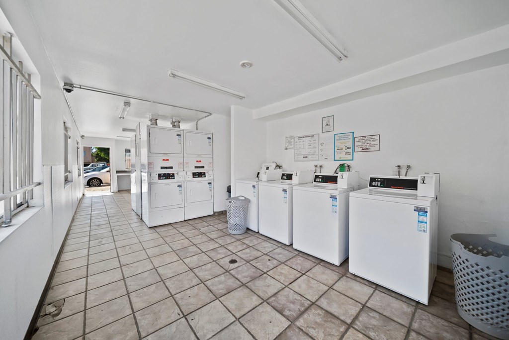 A room with white appliances and a tiled floor.